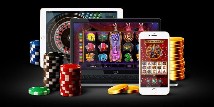 Platta, dator och mobil med diverse casinospel samt spelmarker och guldmynt